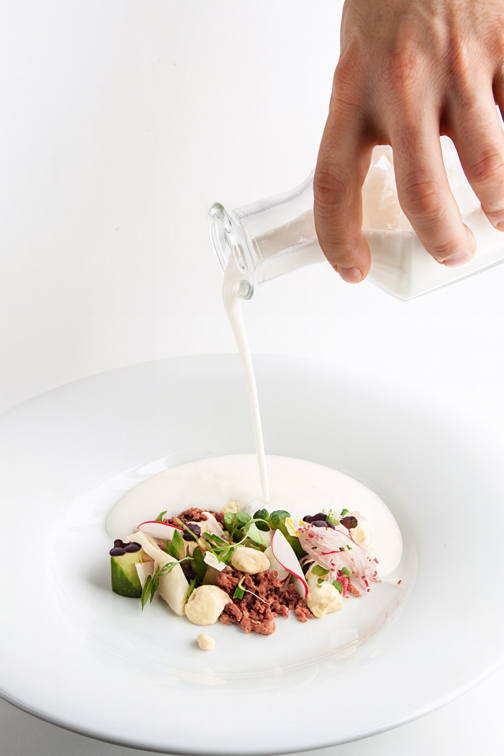 Crème versée sur un plat de légumes