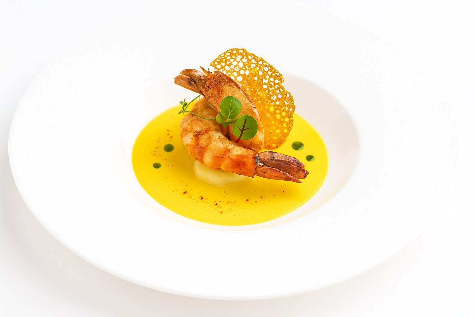 Plat gastronomique aux gambas avec tuile croustillante
